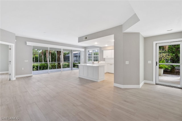 unfurnished living room with plenty of natural light and light hardwood / wood-style flooring