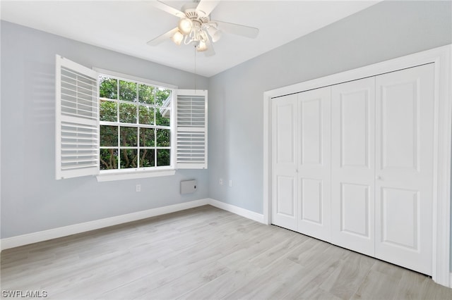 unfurnished bedroom featuring ceiling fan, light hardwood / wood-style floors, and a closet