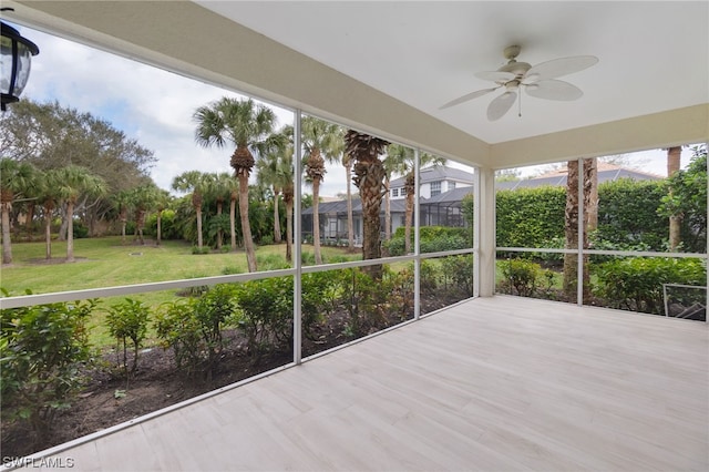 unfurnished sunroom with ceiling fan