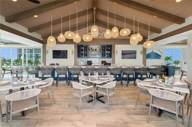 dining area with beam ceiling, light hardwood / wood-style floors, and high vaulted ceiling