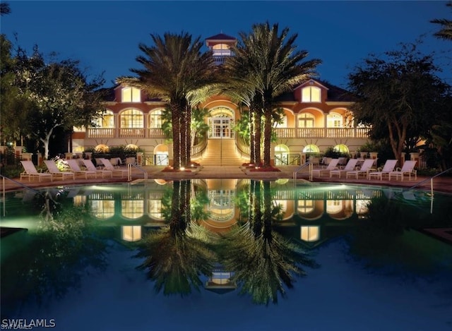 view of pool at twilight