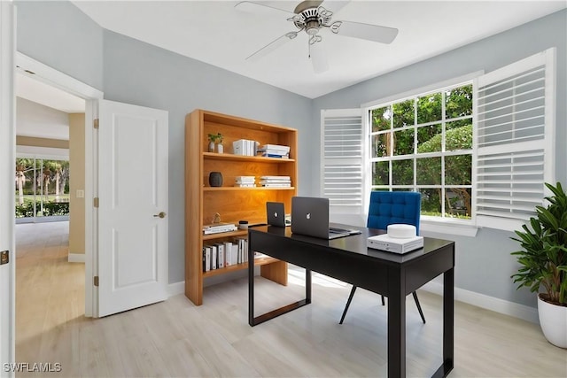 office with light wood-type flooring and ceiling fan