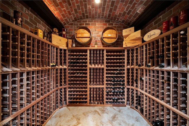 wine room featuring brick wall, brick ceiling, tile floors, and lofted ceiling