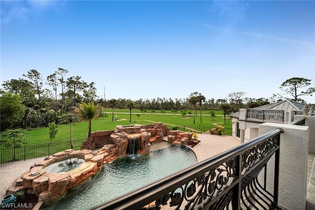 view of swimming pool with a yard, an in ground hot tub, and pool water feature