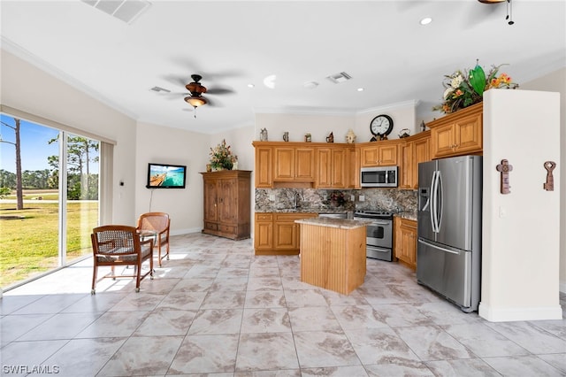 kitchen featuring stainless steel appliances, light tile floors, a kitchen island, ceiling fan, and backsplash