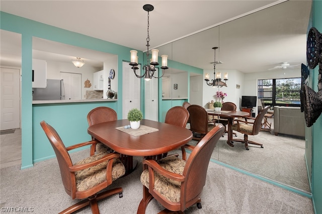 dining area with ceiling fan with notable chandelier and light colored carpet