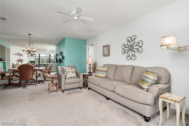 carpeted living room featuring ceiling fan with notable chandelier