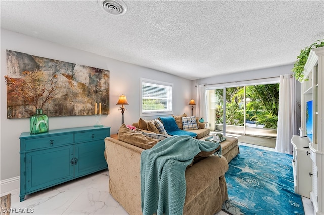 living room with a textured ceiling and plenty of natural light