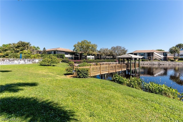 view of dock featuring a water view and a yard