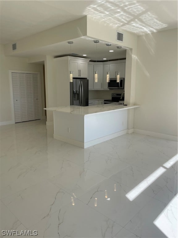 kitchen featuring light tile floors, kitchen peninsula, appliances with stainless steel finishes, white cabinets, and hanging light fixtures