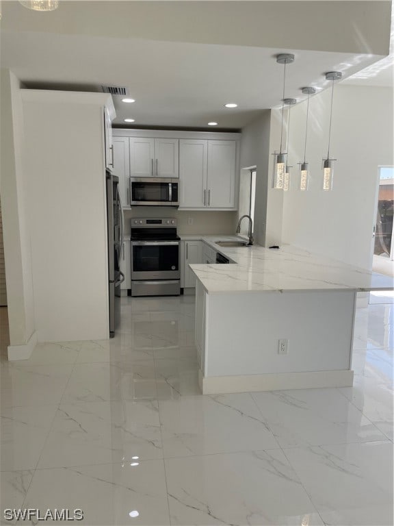 kitchen featuring light tile flooring, kitchen peninsula, decorative light fixtures, and appliances with stainless steel finishes