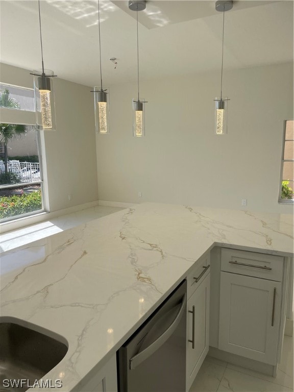 kitchen with hanging light fixtures, light tile floors, stainless steel dishwasher, and light stone counters