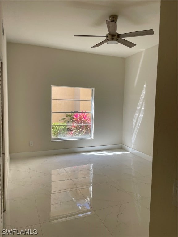 tiled spare room featuring ceiling fan