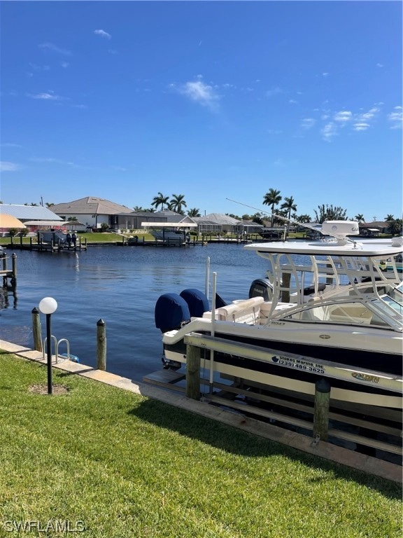 dock area featuring a water view and a lawn