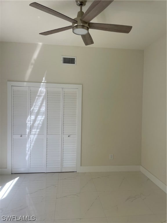 interior space featuring ceiling fan, a closet, and light tile floors