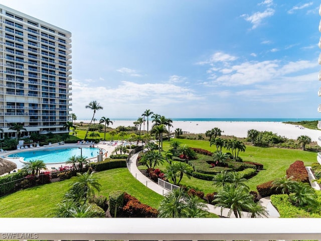 view of pool with a water view and a lawn