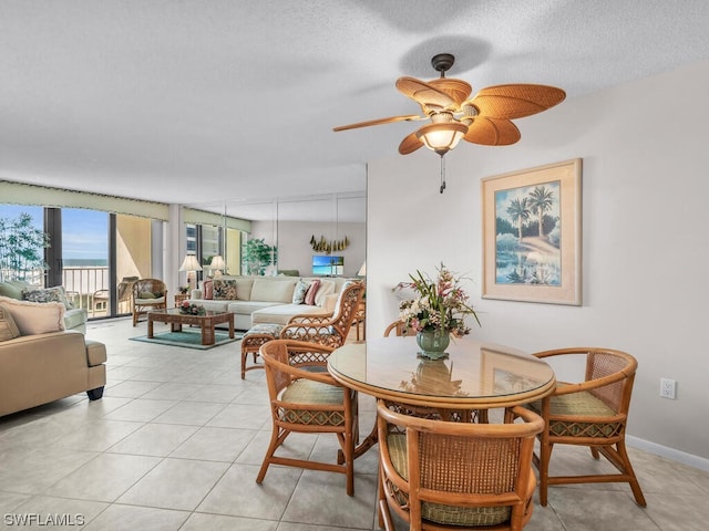 dining space with ceiling fan, a textured ceiling, and light tile patterned floors