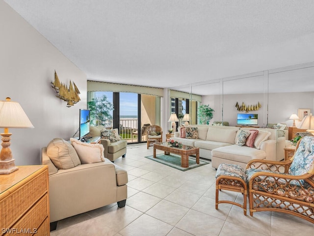 living room featuring light tile patterned floors, a textured ceiling, and a wall of windows