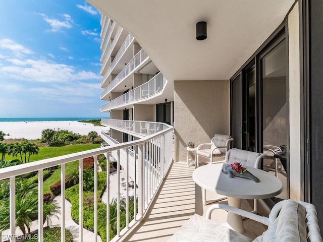 balcony with a water view and a beach view