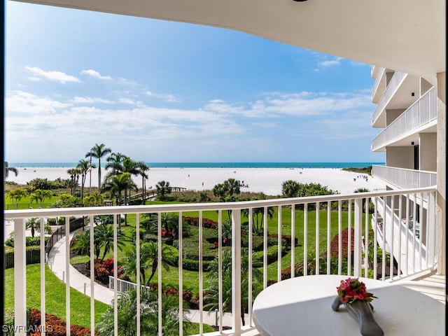 balcony with a water view and a view of the beach