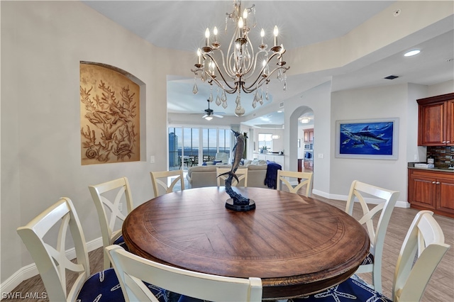 dining area featuring ceiling fan with notable chandelier and light wood-type flooring