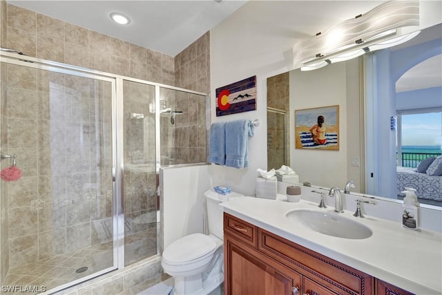 bathroom with walk in shower, vanity, and toilet