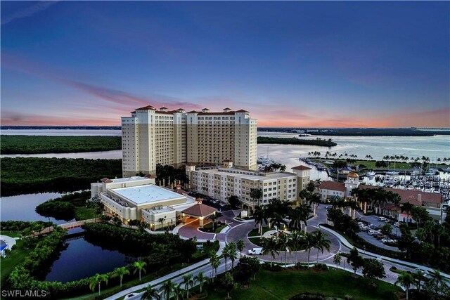 aerial view at dusk featuring a water view