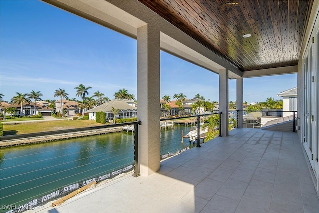 view of patio featuring a water view and a balcony