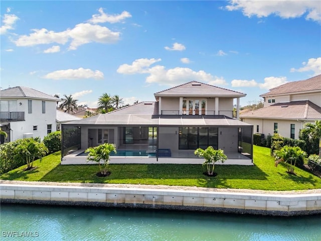 back of house featuring glass enclosure, a patio, a water view, a yard, and an outdoor pool