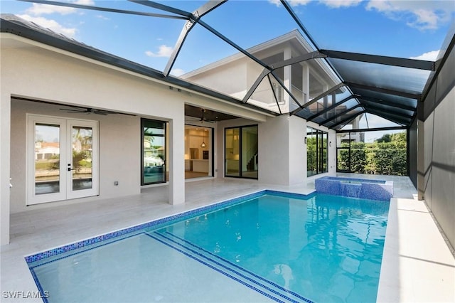 outdoor pool featuring an in ground hot tub, glass enclosure, a ceiling fan, and a patio