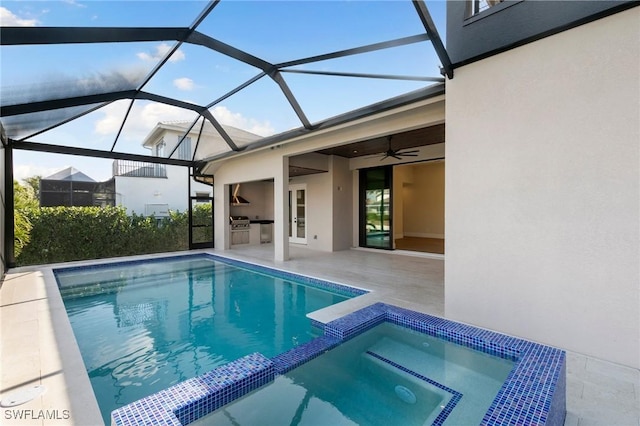 view of swimming pool featuring an outdoor kitchen, a patio, ceiling fan, a lanai, and a pool with connected hot tub