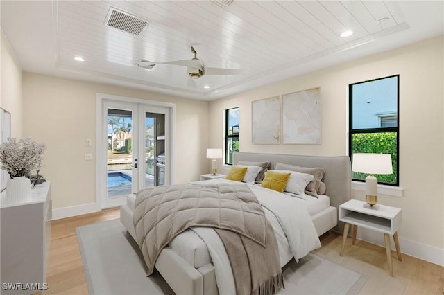 bedroom with access to outside, visible vents, light wood-style flooring, and multiple windows