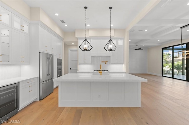 kitchen featuring appliances with stainless steel finishes, wine cooler, glass insert cabinets, and white cabinetry