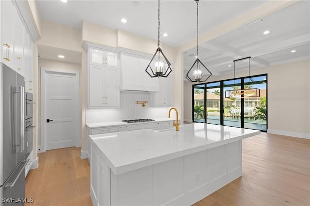 kitchen featuring hanging light fixtures, high end refrigerator, glass insert cabinets, and white cabinets