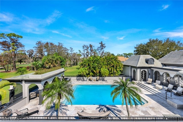 view of pool with a patio area and a lawn