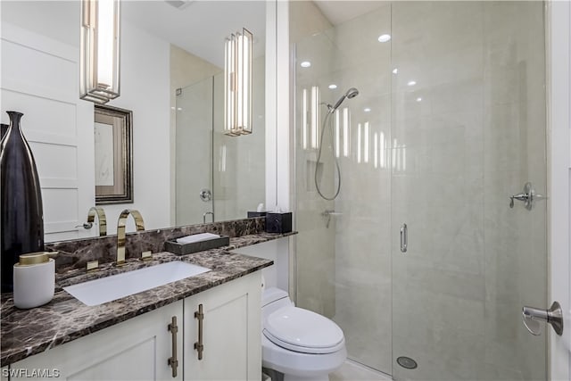 bathroom featuring vanity, toilet, and an enclosed shower