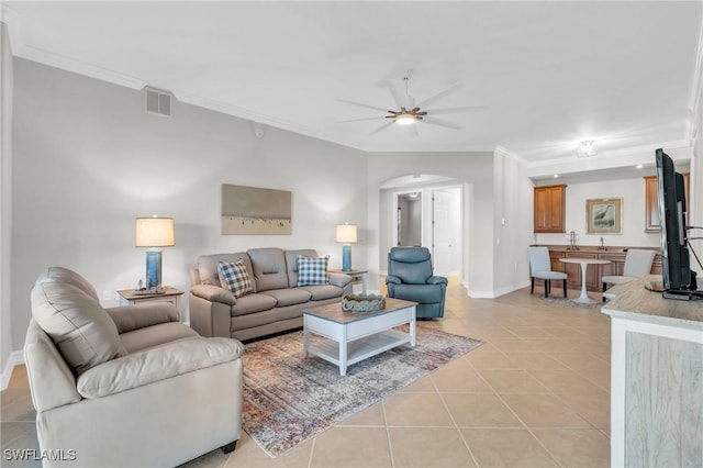 living room with light tile patterned floors, ceiling fan, and crown molding