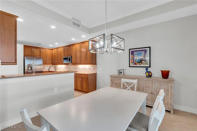 dining room featuring sink, light tile patterned flooring, and a chandelier