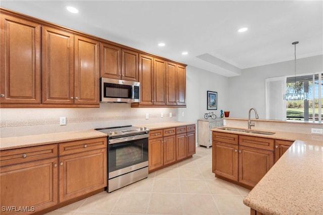 kitchen featuring appliances with stainless steel finishes, light stone counters, sink, pendant lighting, and light tile patterned flooring