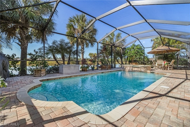 view of swimming pool featuring glass enclosure and a patio