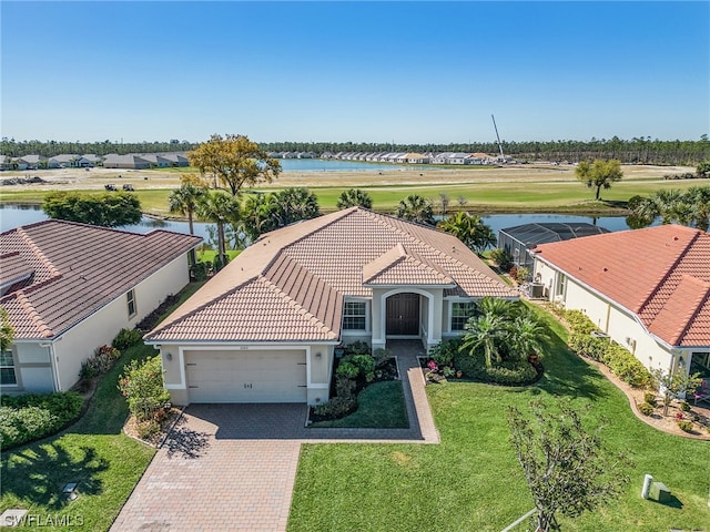 view of front of home featuring a front lawn, a garage, and a water view