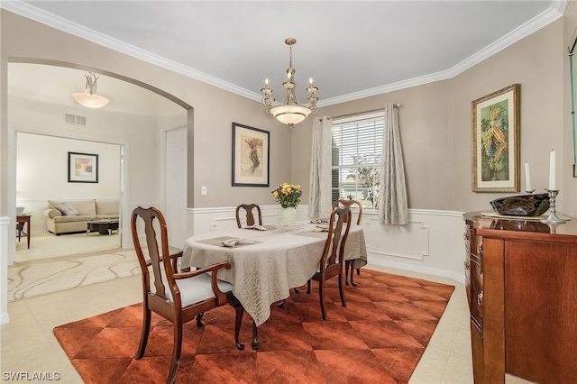 tiled dining room with ornamental molding and a notable chandelier