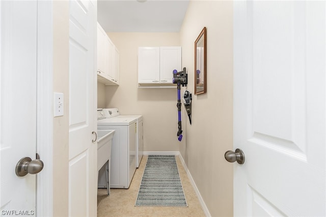 laundry room with cabinets, washer and dryer, and light tile floors