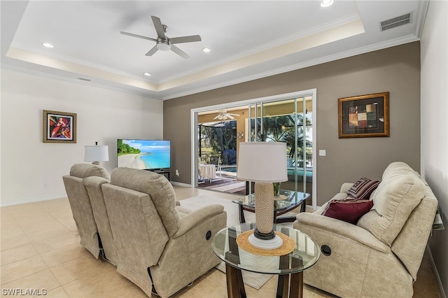 tiled living room with a raised ceiling, ceiling fan, and crown molding