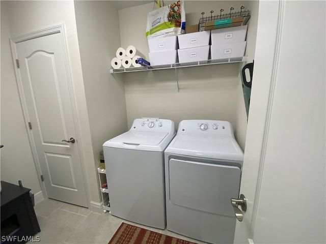 laundry room featuring light tile patterned floors and washing machine and clothes dryer