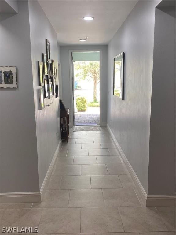 hallway featuring baseboards and tile patterned floors