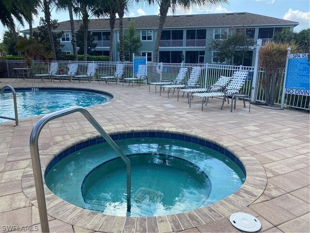 view of pool with a community hot tub and a patio area