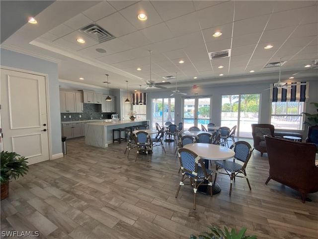 dining area featuring ceiling fan, ornamental molding, and visible vents