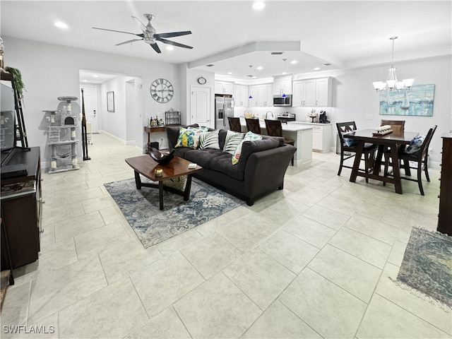 living room with light tile patterned floors and ceiling fan with notable chandelier