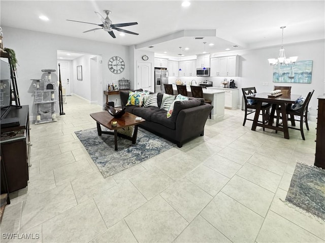 living room featuring light tile patterned flooring, baseboards, ceiling fan with notable chandelier, and recessed lighting